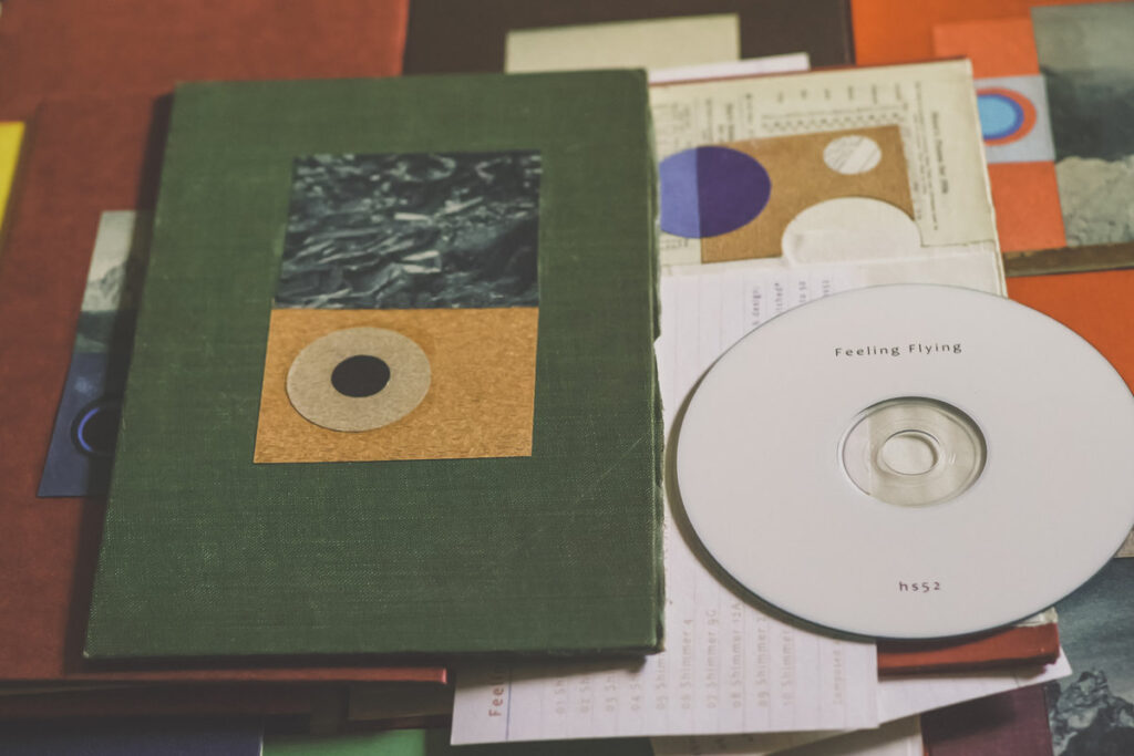 Photo showing examples of the Feeling Flying CD cases, with different colours and designs.